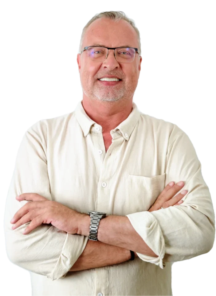 N.D. Brandt, smiling, arms folded, in a pale linen shirt.